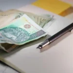 Couple signant un contrat d'assurance emprunteur dans une agence bancaire