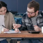 Ce que les établissements ne vous diront jamais sur le rachat de crédit Couple stressé face à des documents de crédit bancaire sur une table
