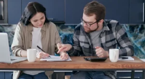 Couple stressé face à des documents de crédit bancaire sur une table