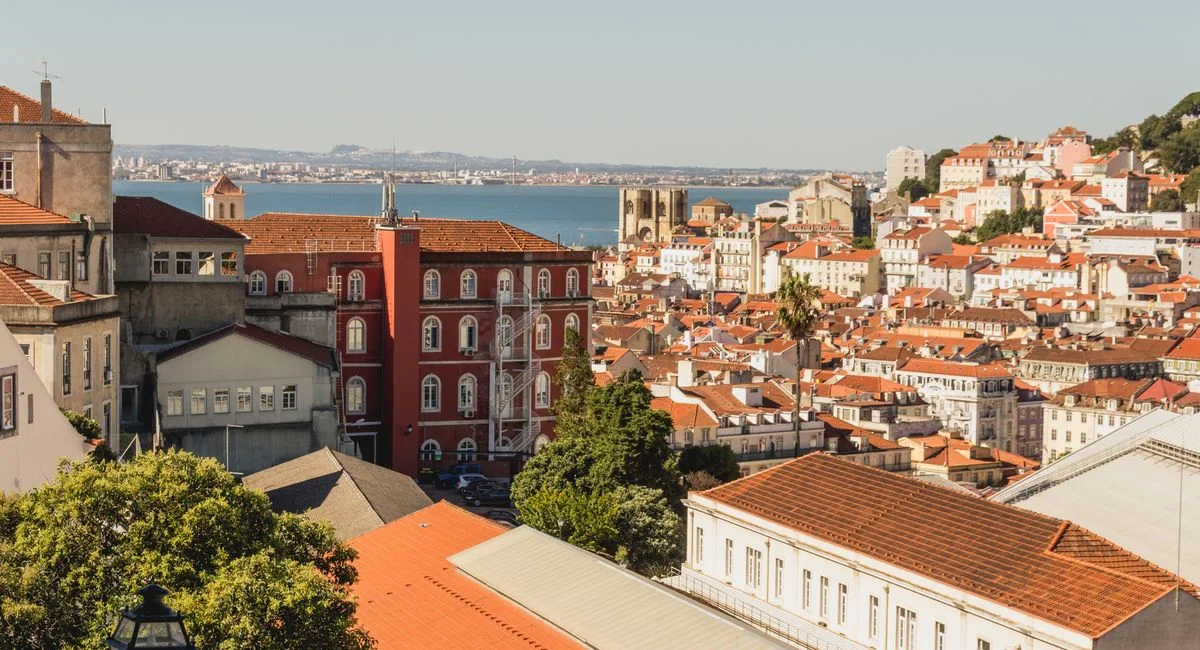 Façade d'immeuble portugais avec agence immobilière et affichage de taux en vitrine