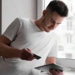 Homme consultant son téléphone pour une demande de crédit fractionné en ligne