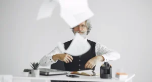 homme de 60 ans consultant ses documents de retraite à son bureau
