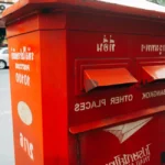 Main déposant un chèque dans une enveloppe au bureau de poste