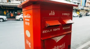 Main déposant un chèque dans une enveloppe au bureau de poste