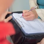Main signant une procuration bancaire sur un bureau de banque