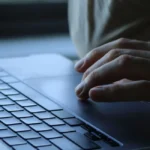 Personne connectée à son compte Ameli sur ordinateur pour modifier coordonnées bancaires