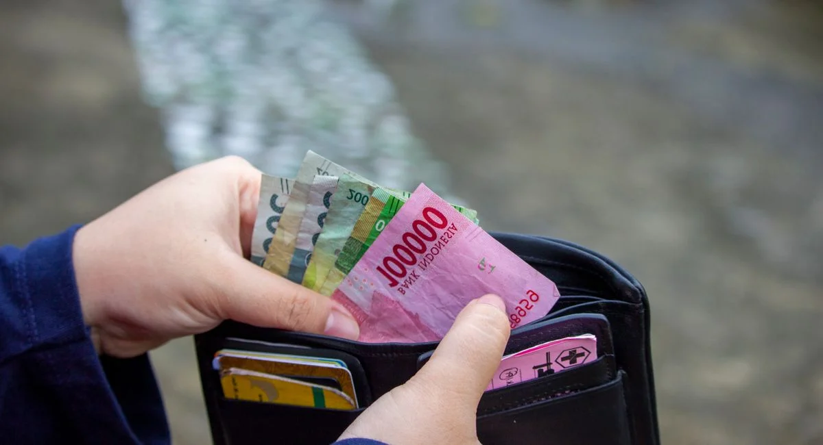 Personne retirant des billets au distributeur automatique de billets