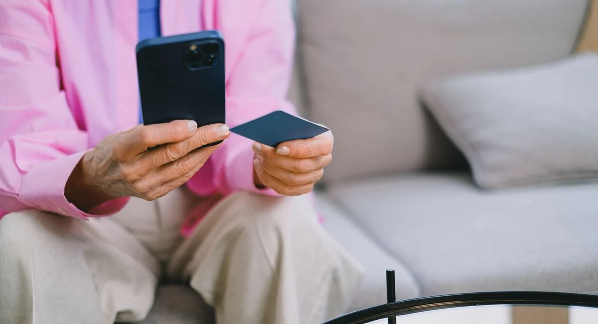 Smartphone posé sur une table avec une application bancaire ouverte et une carte bleue