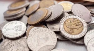 Carnet épargne ouvert posé sur table avec pièce de monnaie à côté