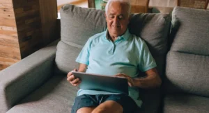 Homme regarde sa tablette devant un graphique d’épargne-retraite