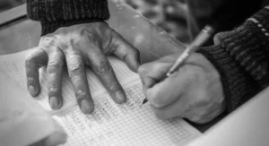 Main qui verse des pièces sur un livret marqué "retraite" sur table de bureau