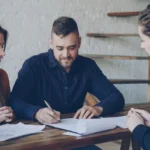 Consultant et investisseur analysant un plan immobilier dans un bureau