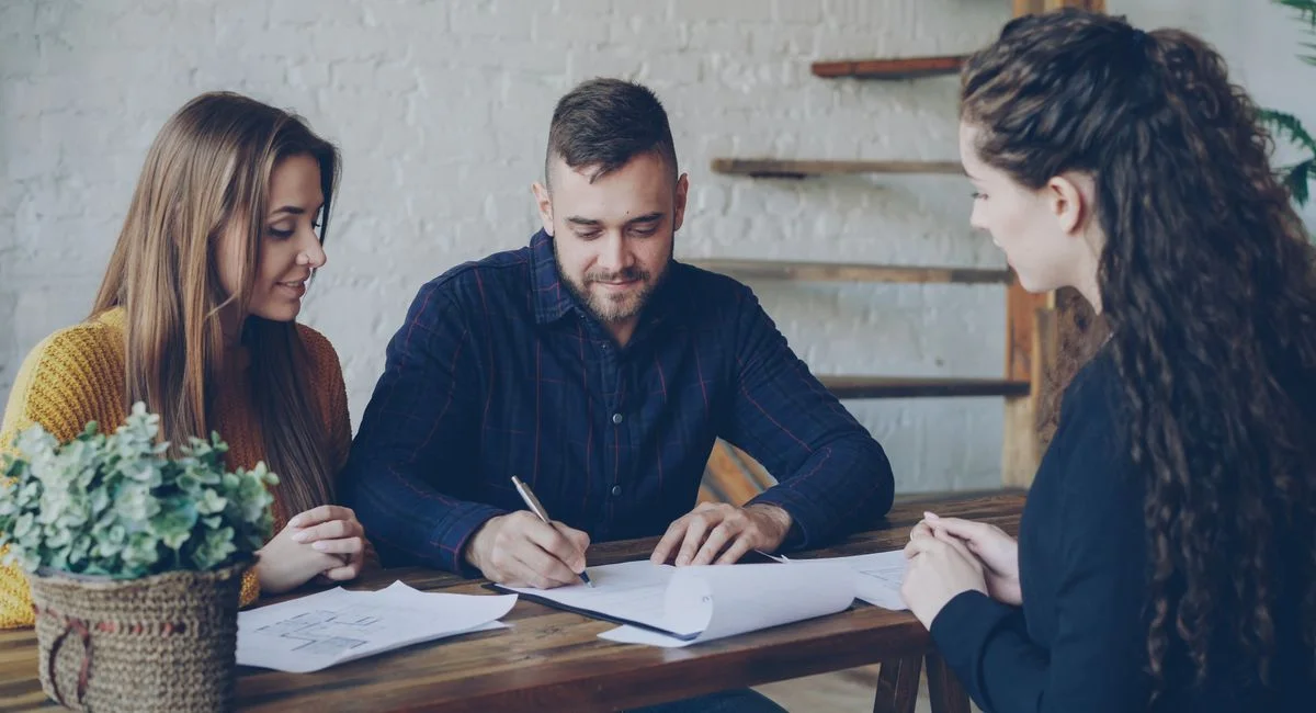Consultant et investisseur analysant un plan immobilier dans un bureau