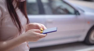 Smartphone affichant un faux SMS ANTAI, main hésitante à cliquer